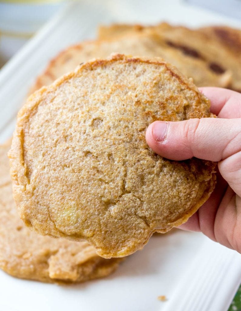 a child's hand holding a Baby Cereal Pancake