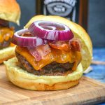 smoked whiskey bacon cheeseburger on a wooden cutting board