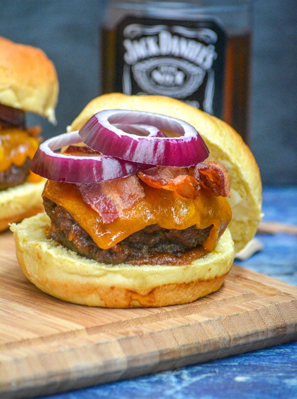 smoked whiskey bacon cheeseburger on a wooden cutting board