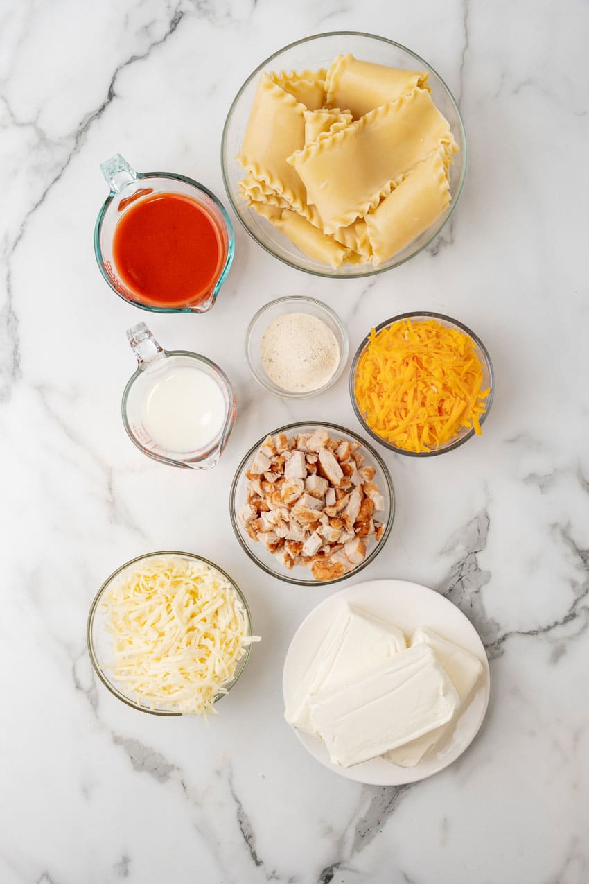 an overhead image showing the measured ingredients to make a cheesy buffalo chicken lasagna