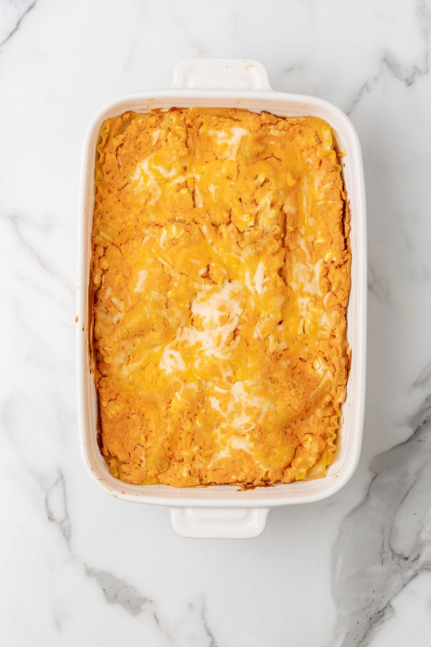 a baked cheesy buffalo chicken lasagna in a white casserole dish