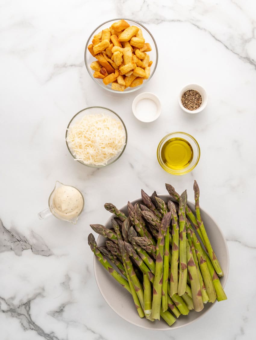 an overhead image showing the measured ingredients needed to make a batch of grilled asparagus caesar style
