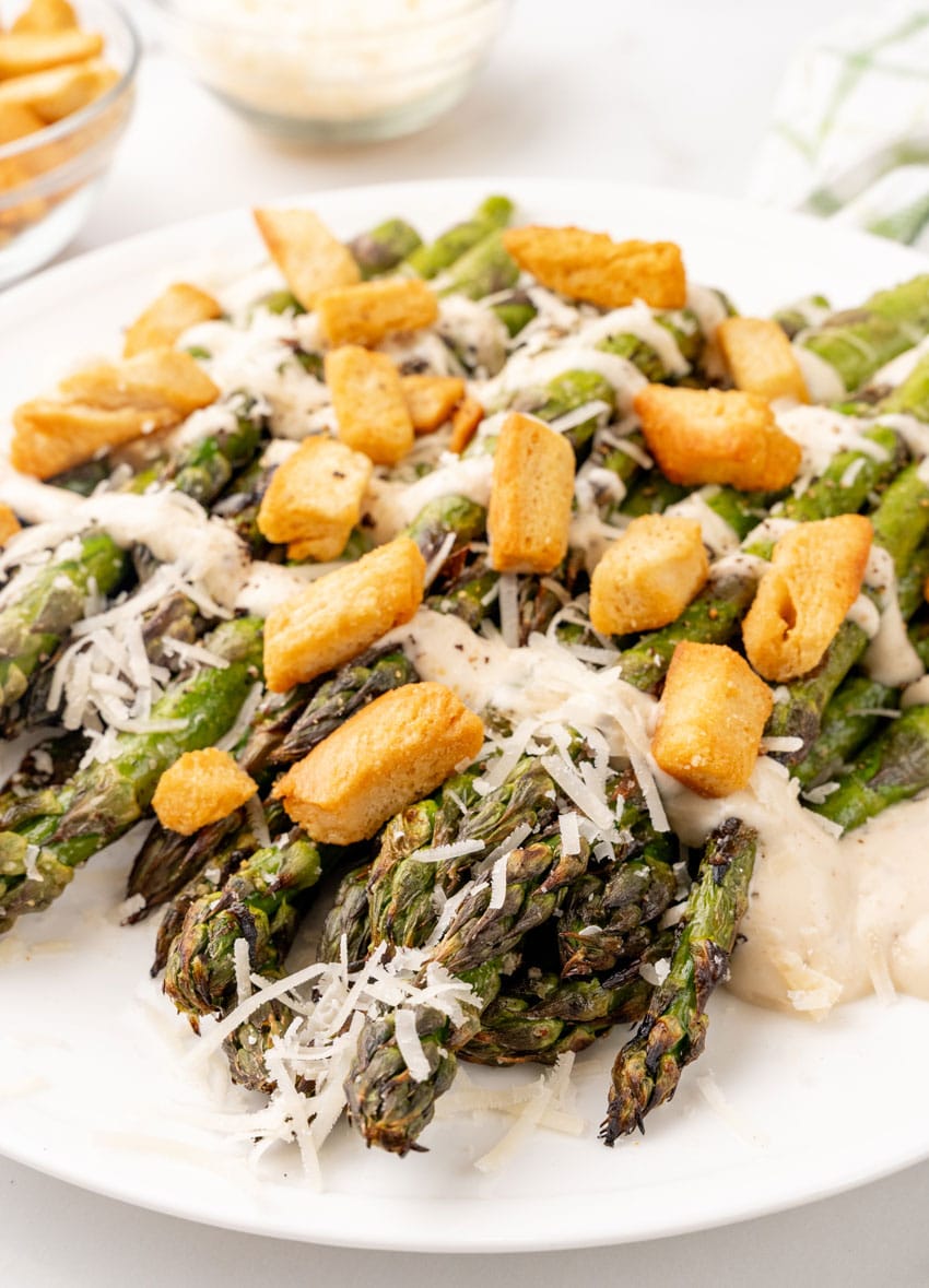caesar style grilled asparagus on a white serving plate