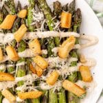 caesar style grilled asparagus on a white serving plate