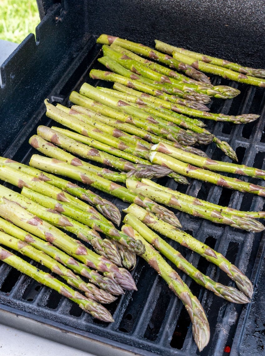 seasoned asparagus spears on a hot grill