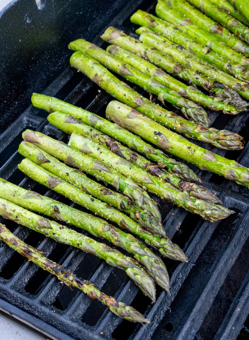 seasoned asparagus spears on a hot grill