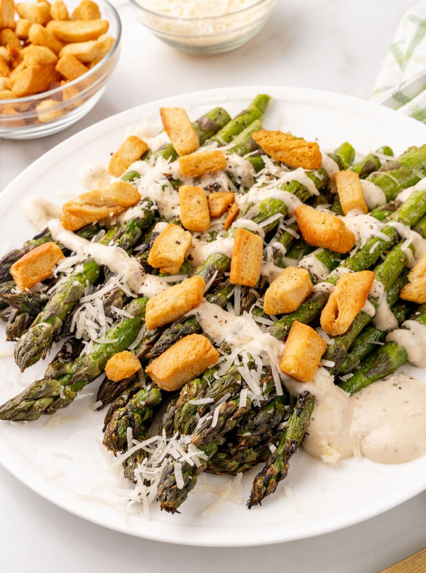 caesar style grilled asparagus on a white serving plate