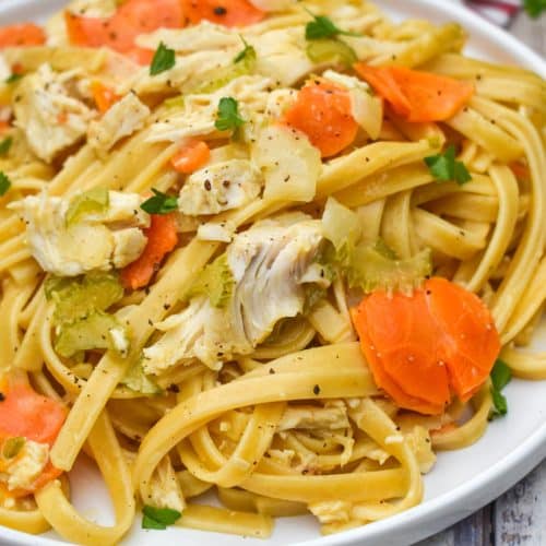creamy chicken and vegetable pasta on a white plate