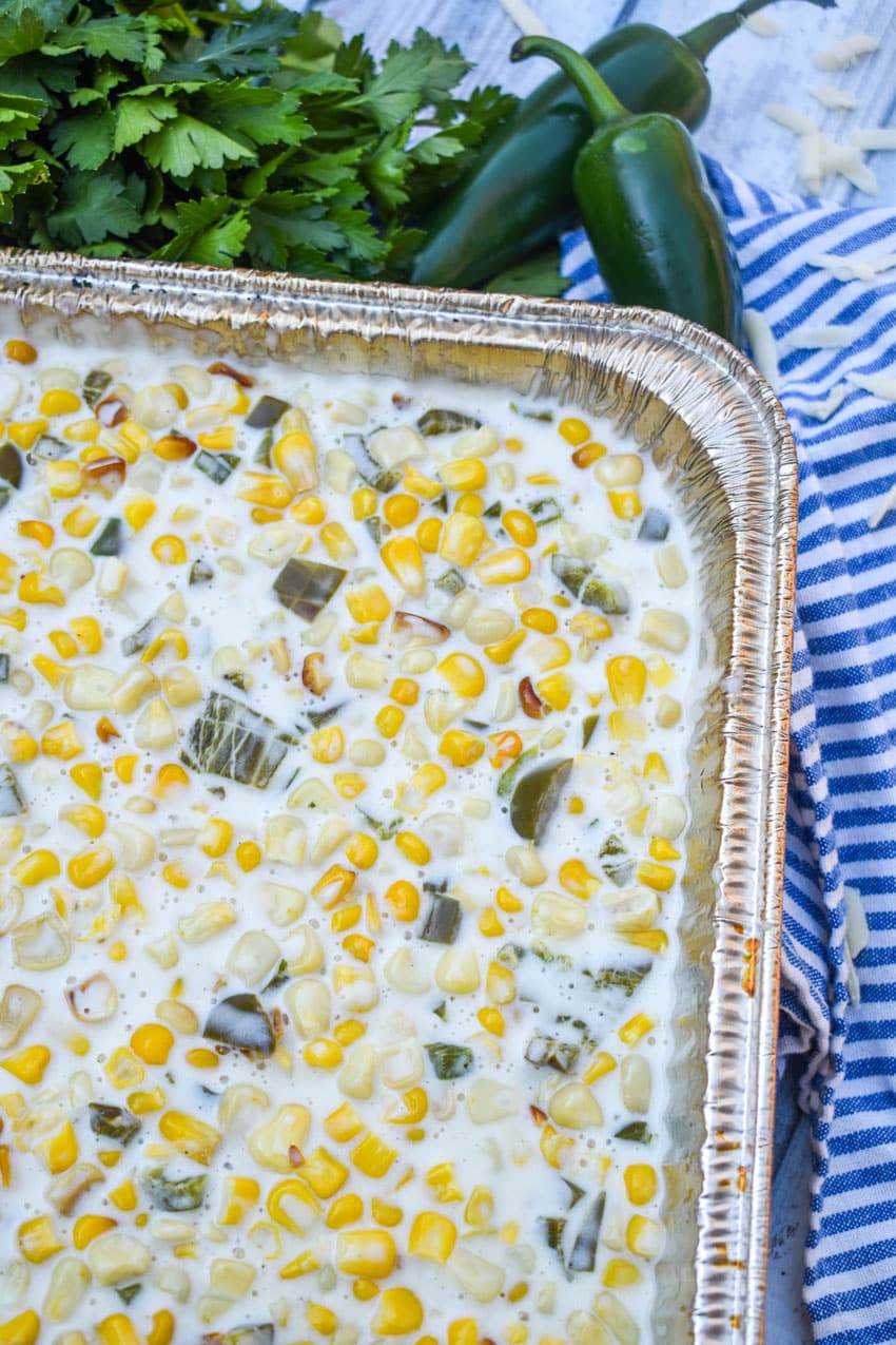 smoked jalapeno cheddar creamed corn in a disposable aluminum pan