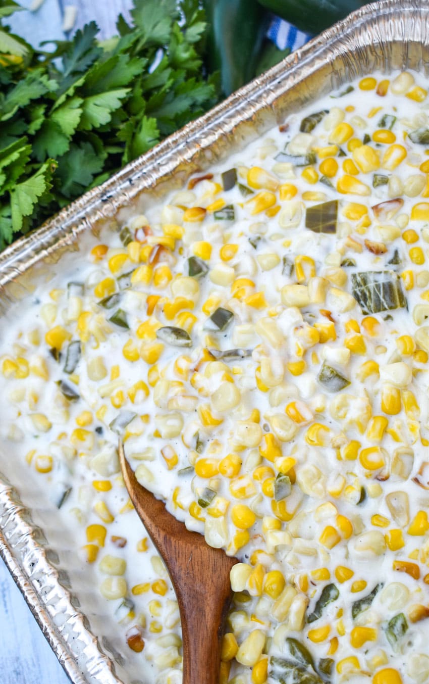 smoked jalapeno cheddar creamed corn in a disposable aluminum pan