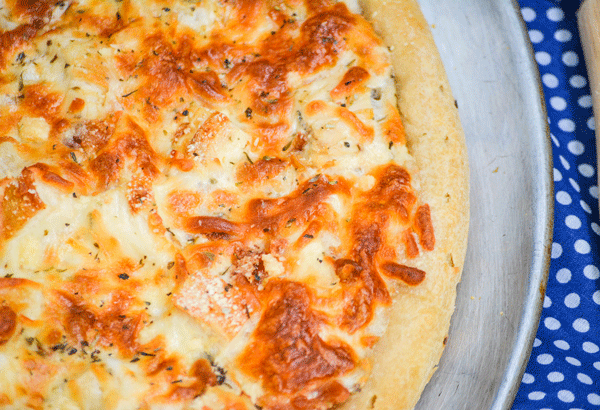 chicken and bacon caesar pizza on a metal pizza pan