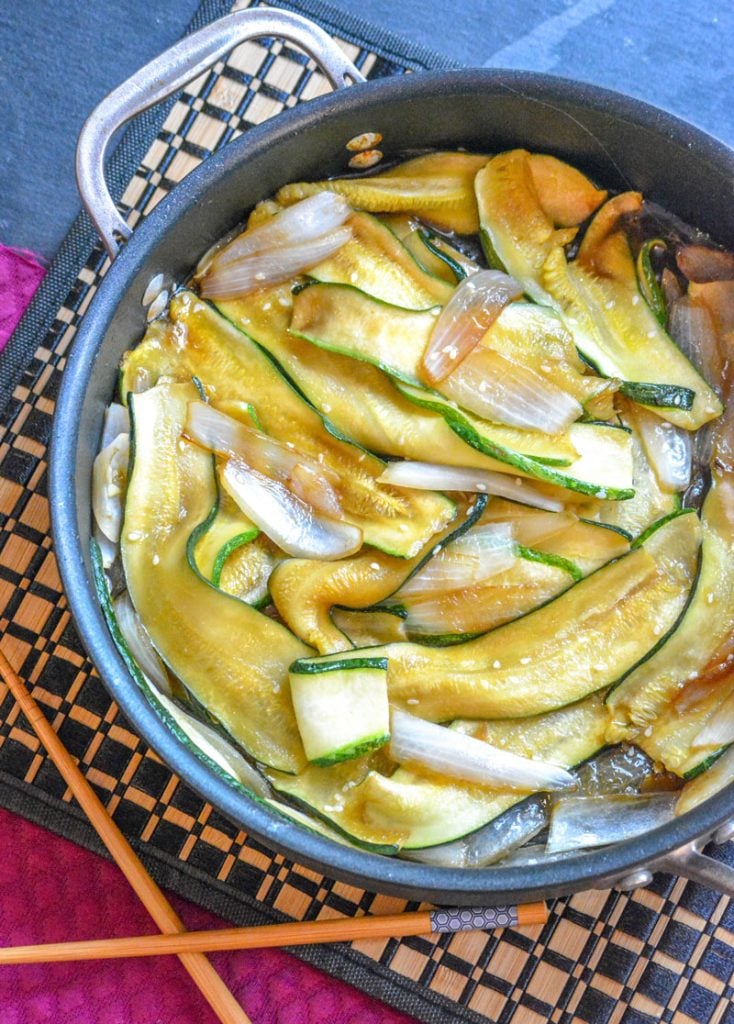 Japanese Steakhouse Hibachi Style Zucchini & Onions shown in a large black skillet with chop sticks to the side