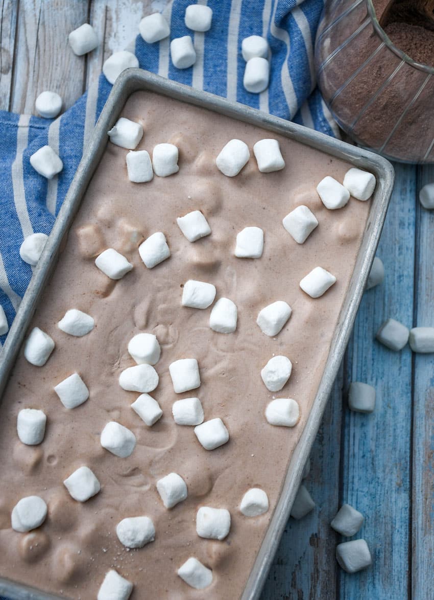 no churn hot chocolate ice cream topped with mini marshmallows in a metal loaf pan