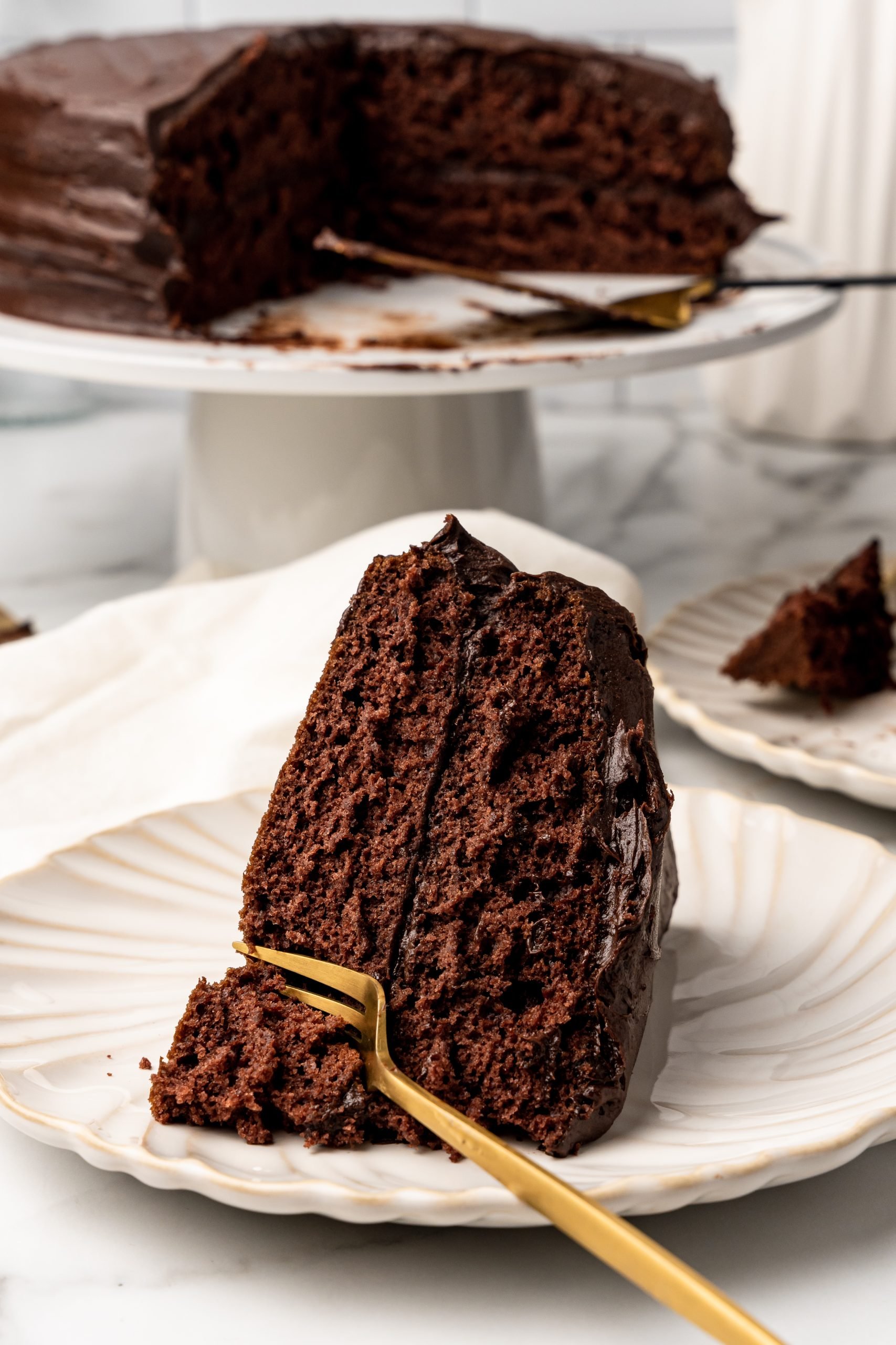 old fashioned chocolate church cake on a white plate with a golden fork