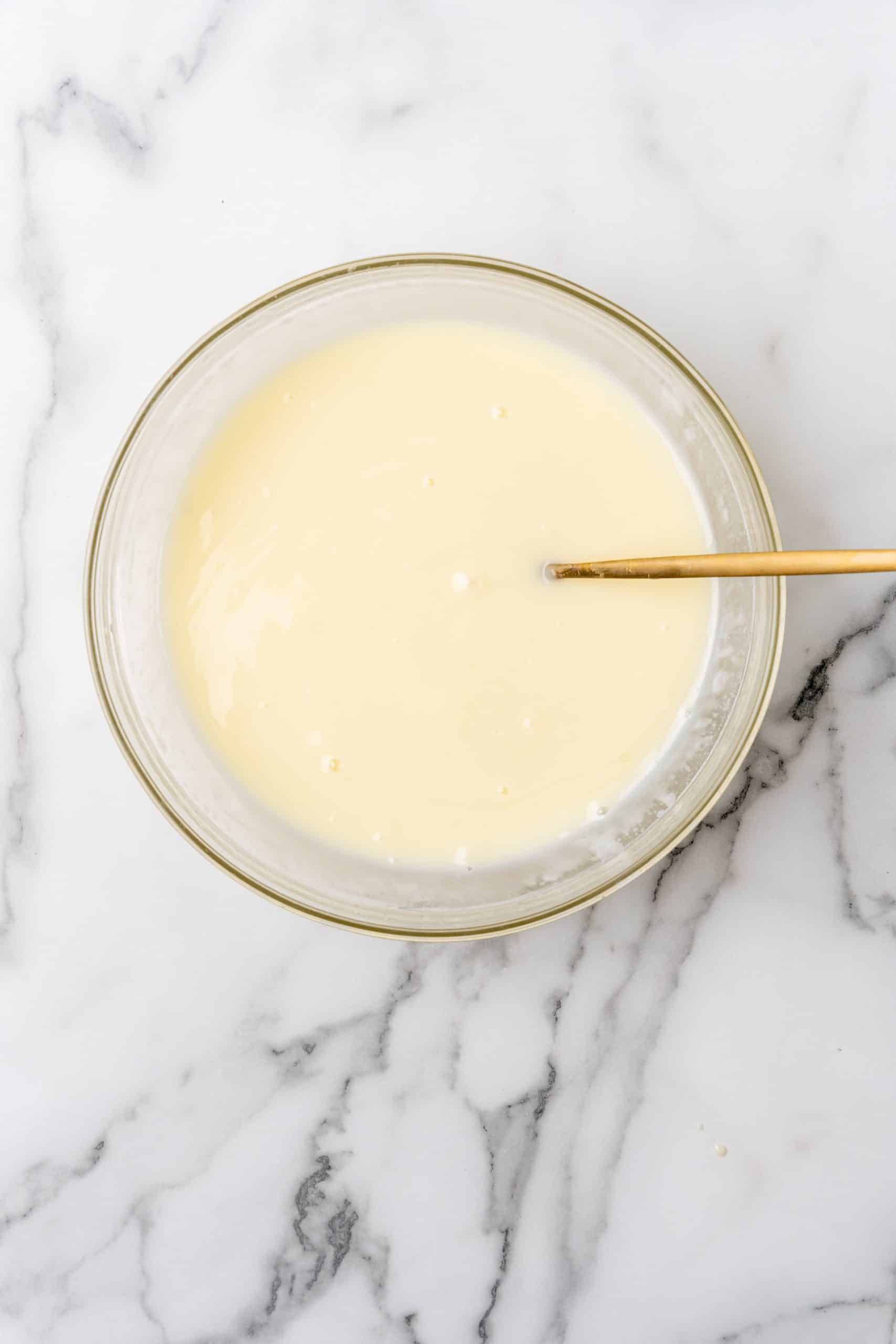 creamy lemonade mixture in a glass mixing bowl