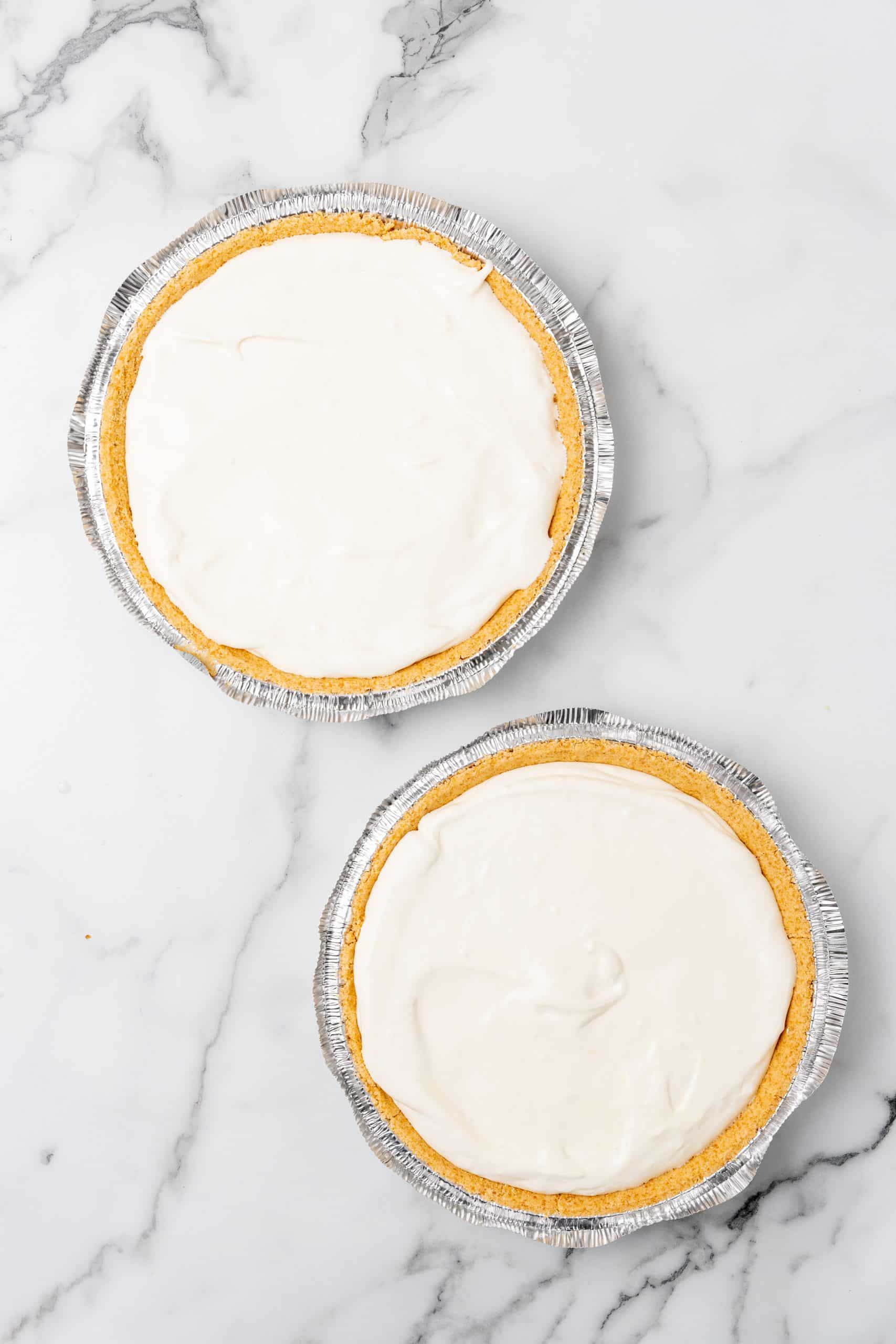 two graham cracker crusts filled with creamy lemonade pie filling