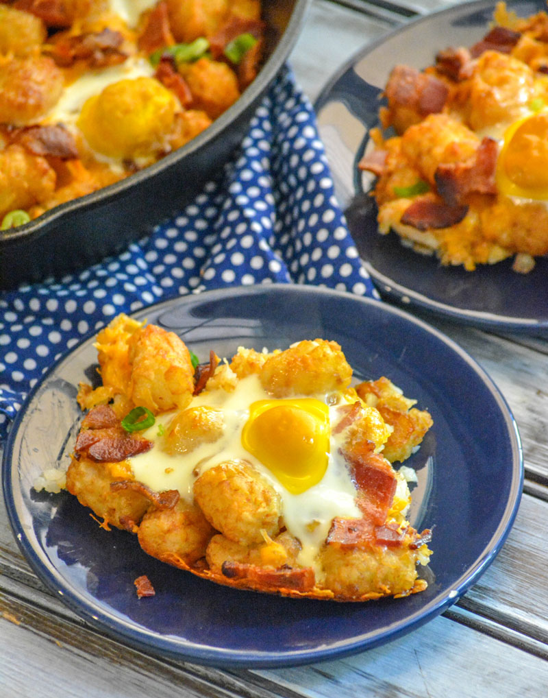 BACON EGG AND CHEESE BREAKFAST TOTCHOS ON A SMALL BLUE PLATE