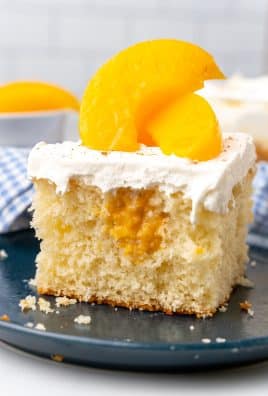 a slice of peaches and cream poke cake on a small blue plate