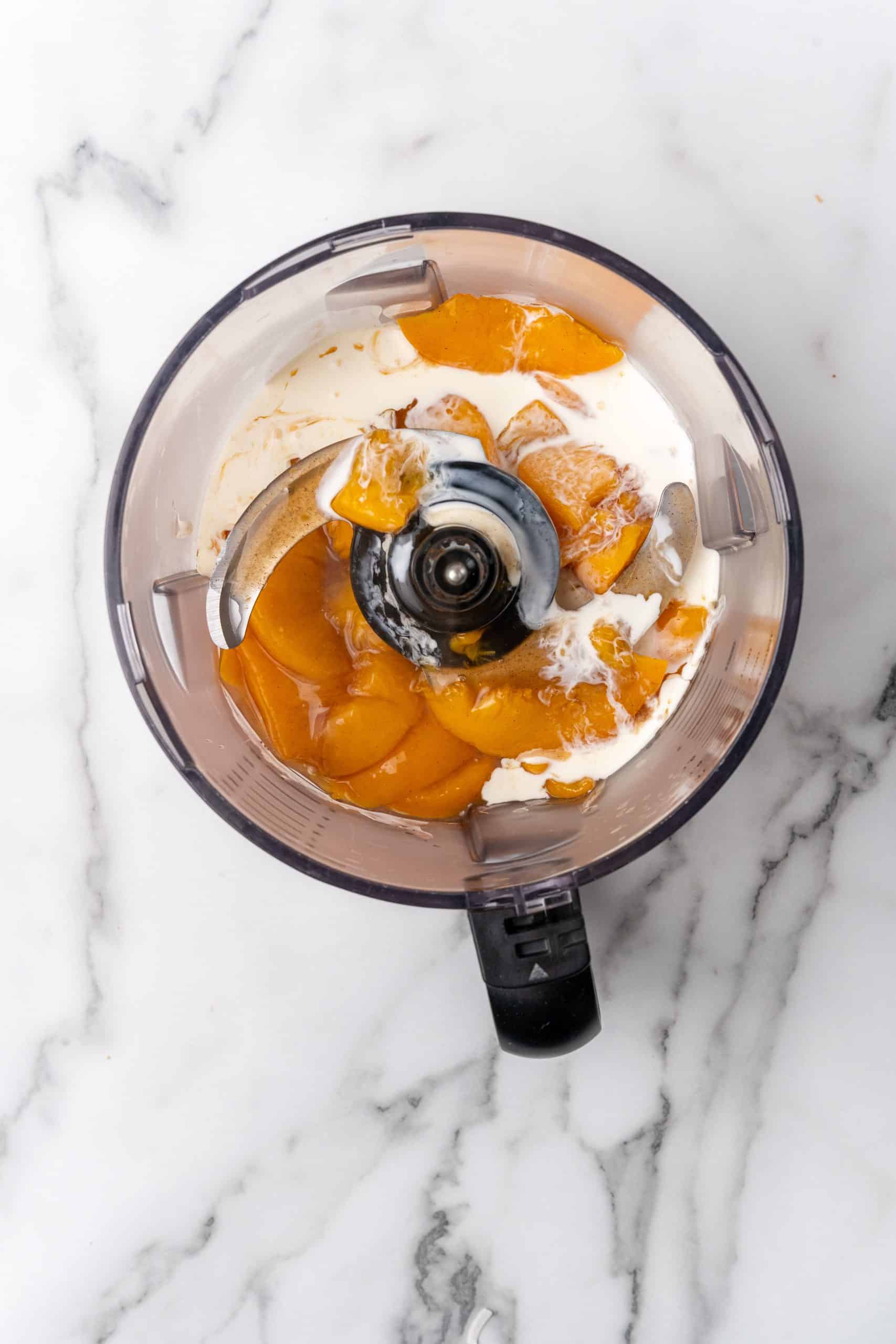 peach pie filling and cream in the bowl of a food processor