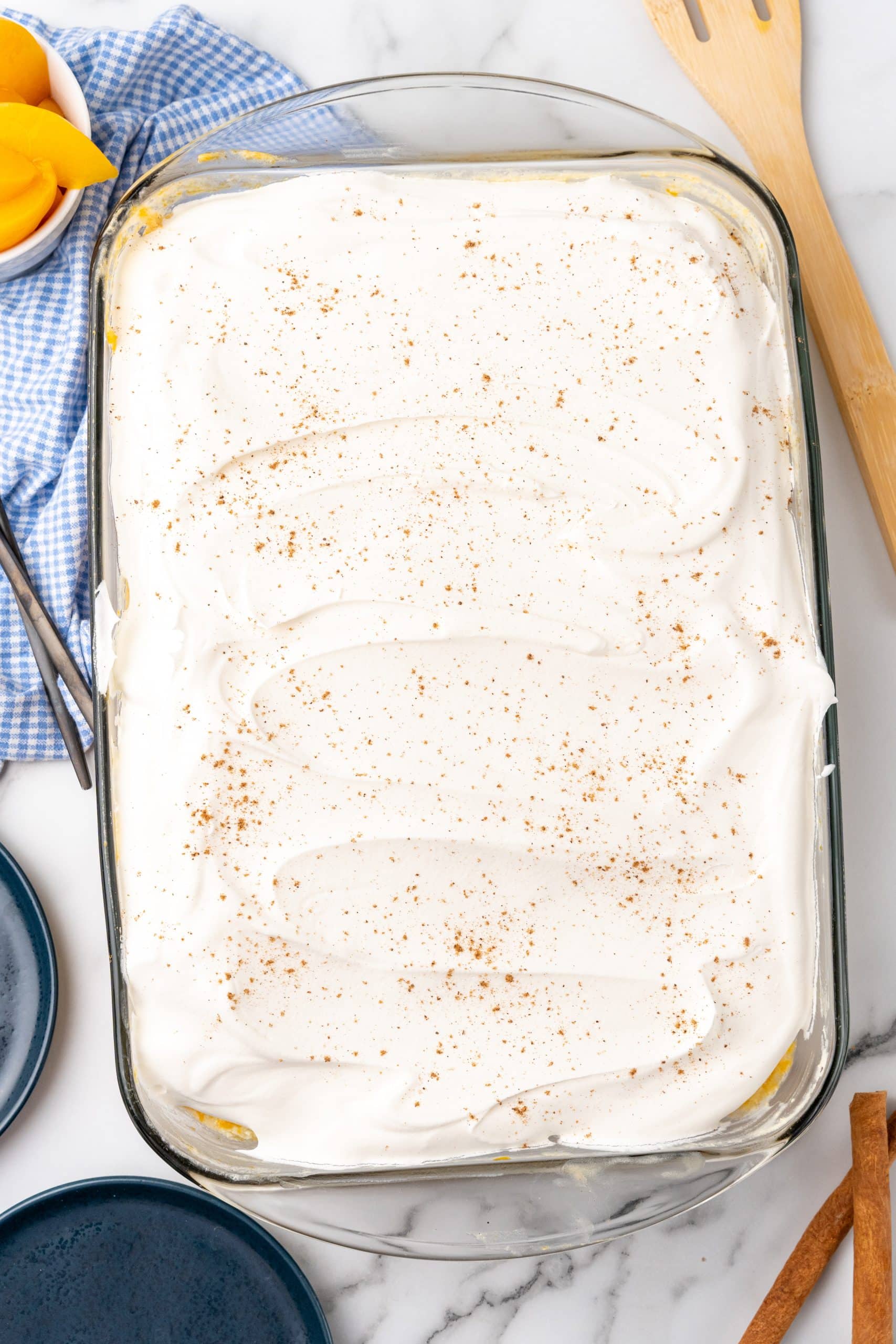 peaches and cream poke cake in a glass baking dish