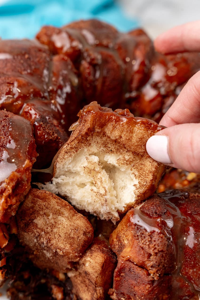 a hand pulling a piece of chocolate monkey bread apart