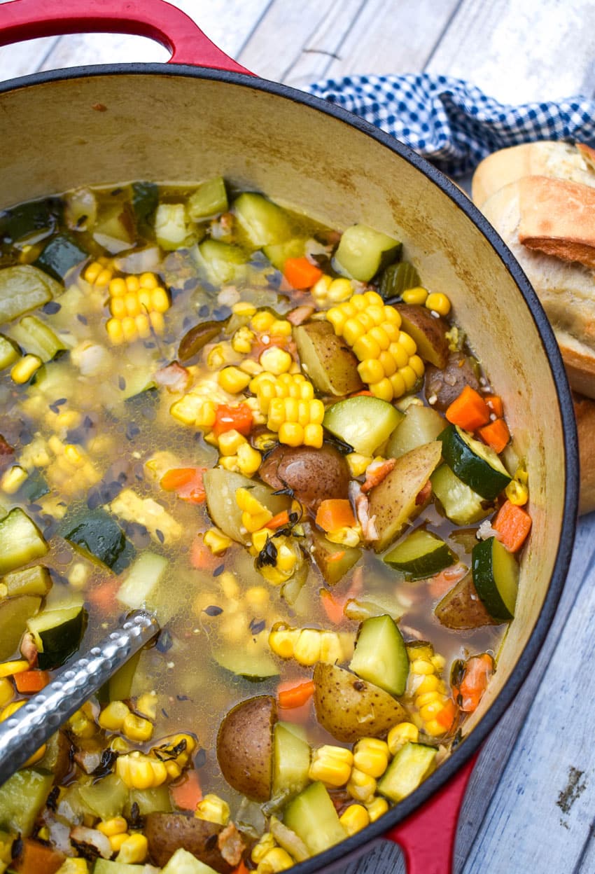 summer soup with zucchini and corn in a red pot