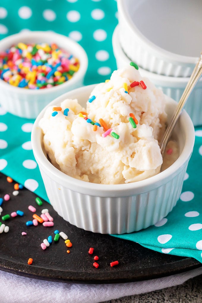 5 Minute Ice Cream In A Bag spooned into a white ramekin with sprinkles on and in the back ground