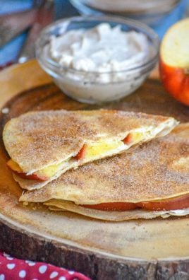 SLICES OF APPLE CHEESECAKE BREAKFAST QUESADILLAS ON A WOODEN CUTTING BOARD