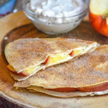 SLICES OF APPLE CHEESECAKE BREAKFAST QUESADILLAS ON A WOODEN CUTTING BOARD