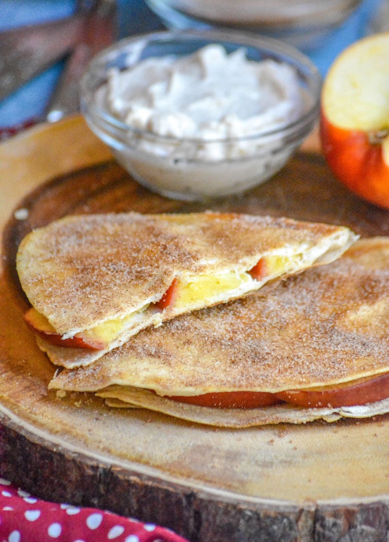 SLICES OF APPLE CHEESECAKE BREAKFAST QUESADILLAS ON A WOODEN CUTTING BOARD