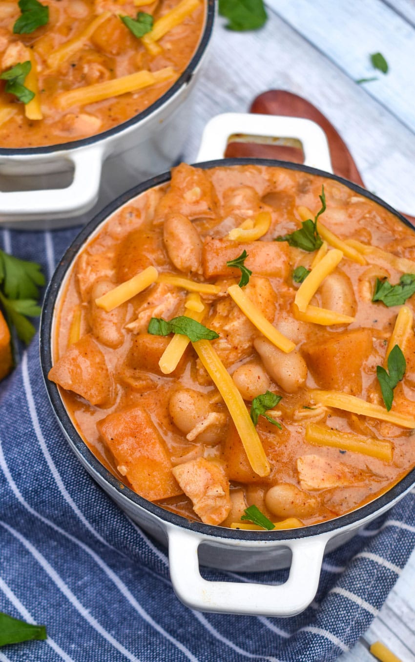 white cheddar apple chicken chili in two small white soup bowls