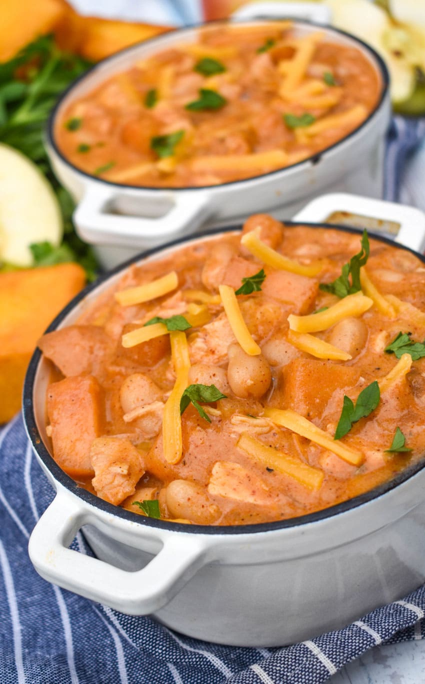 white cheddar apple chicken chili in two small white soup bowls