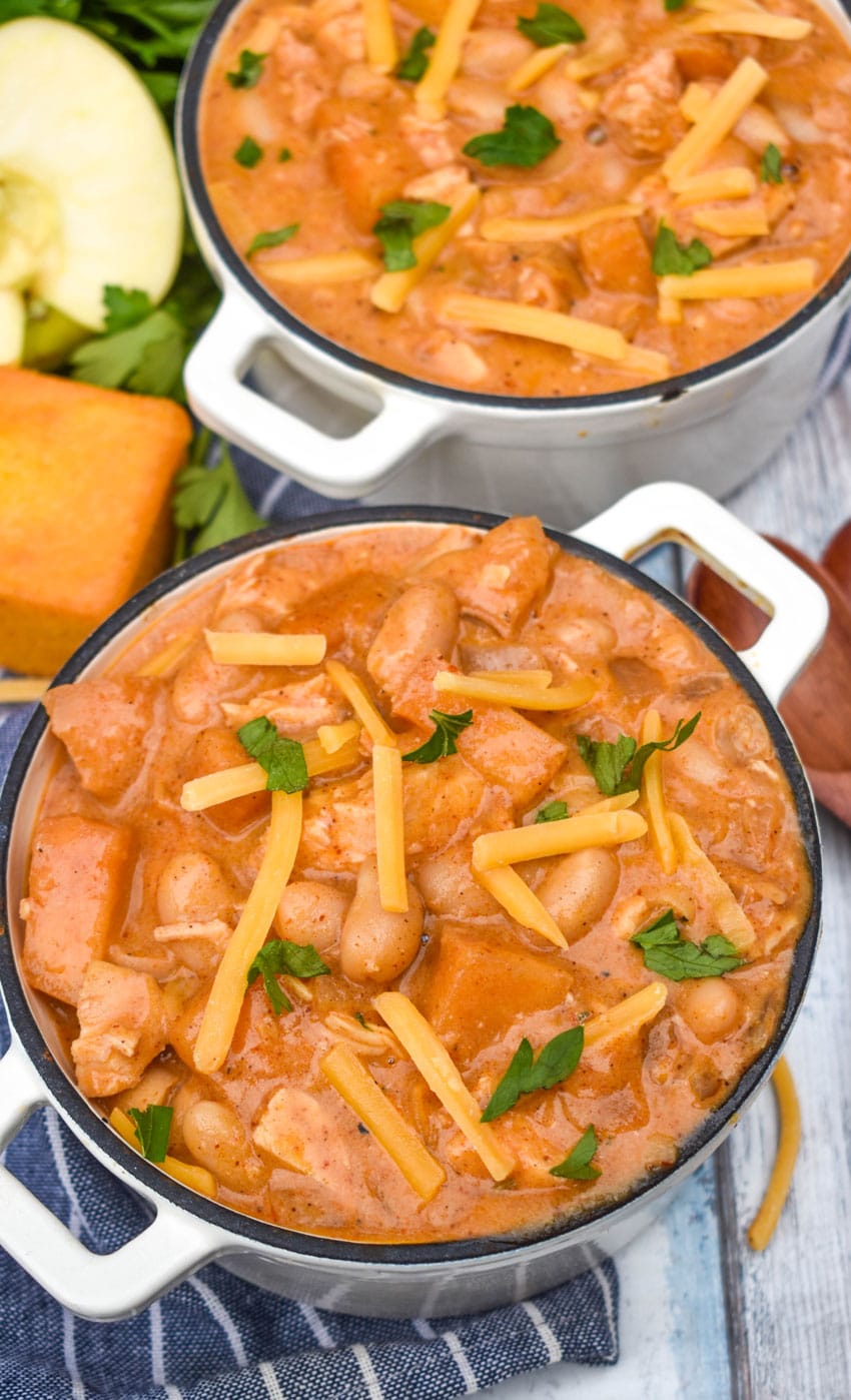 white cheddar apple chicken chili in two small white soup bowls