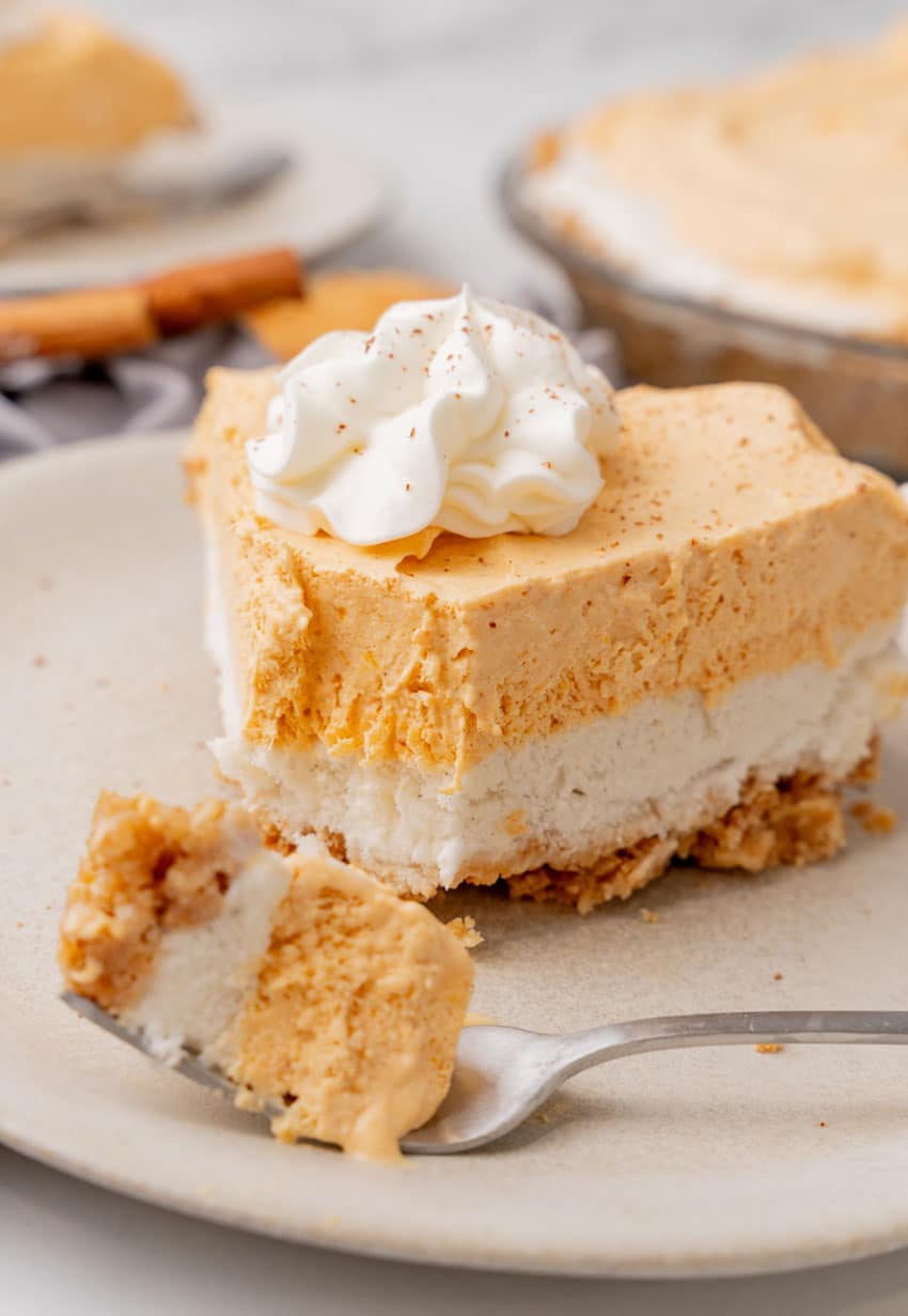 a slice of pumpkin ice cream pie on a white plate with a silver fork resting on the side