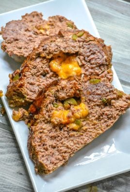 THREE SLICES OF BUTTERMILK JALAPENO CHEDDAR STUFFED MEATLOAF ON A WHITE SERVING PLATTER