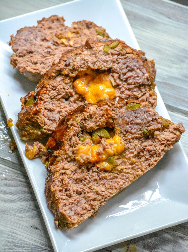 THREE SLICES OF BUTTERMILK JALAPENO CHEDDAR STUFFED MEATLOAF ON A WHITE SERVING PLATTER