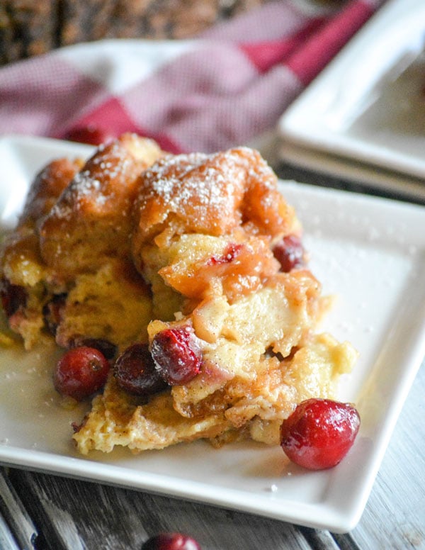 a slice of cranberry donut bread pudding on a small white dessert plate