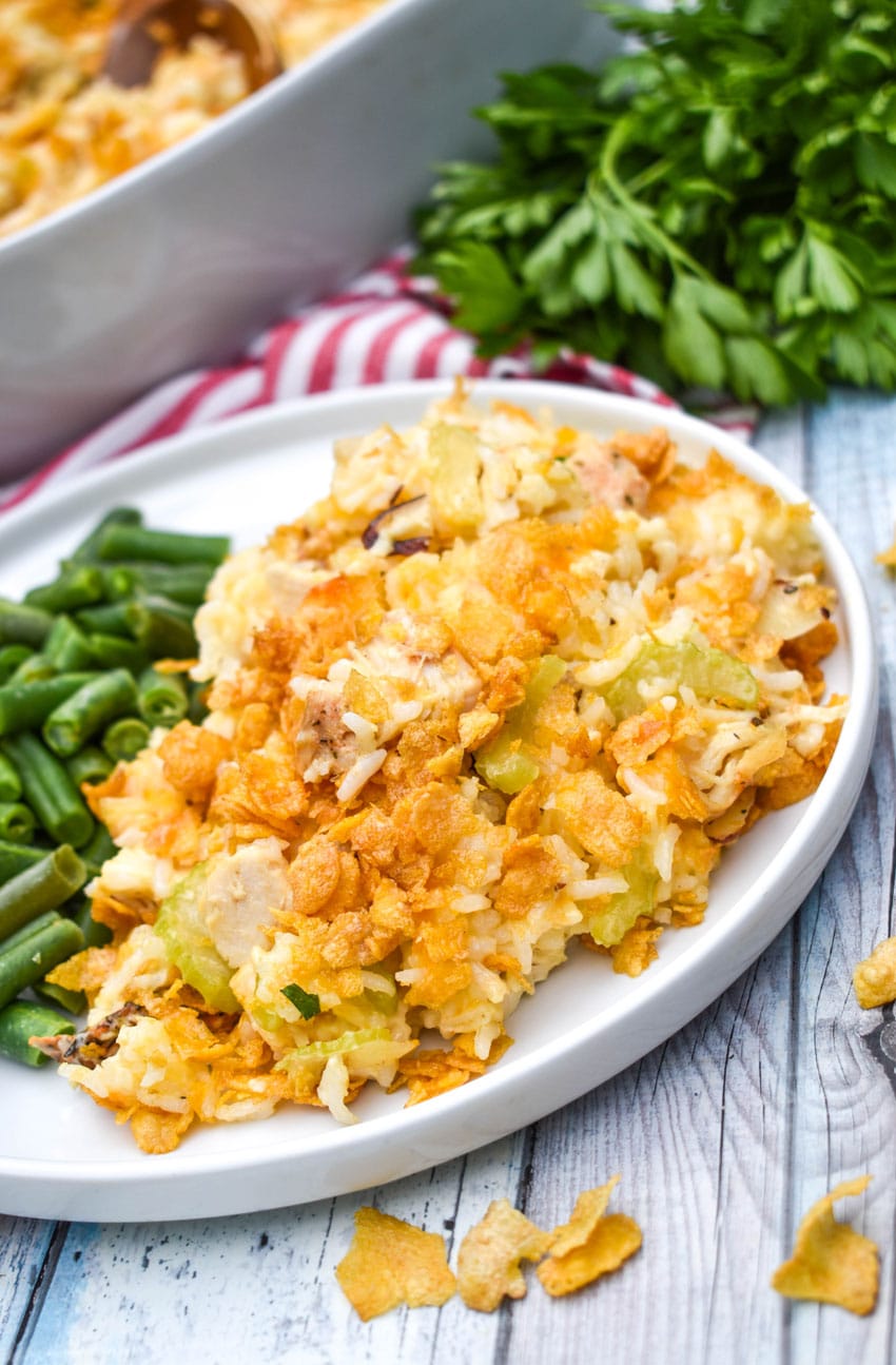 rotisserie chicken and rice casserole next to steamed green beans on a white plate