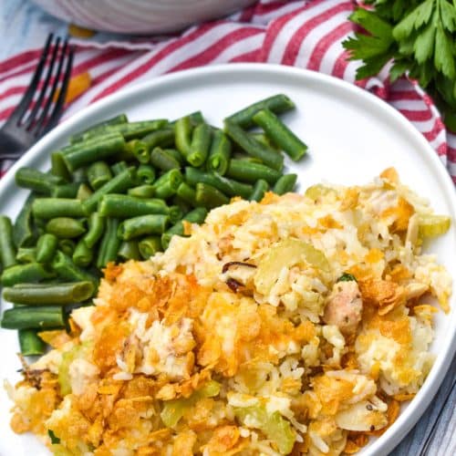 rotisserie chicken and rice casserole next to steamed green beans on a white plate