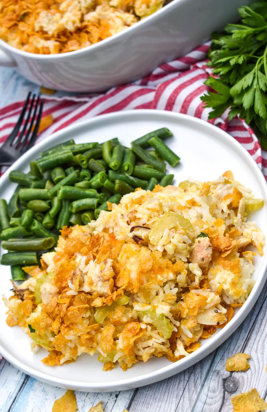 rotisserie chicken and rice casserole next to steamed green beans on a white plate