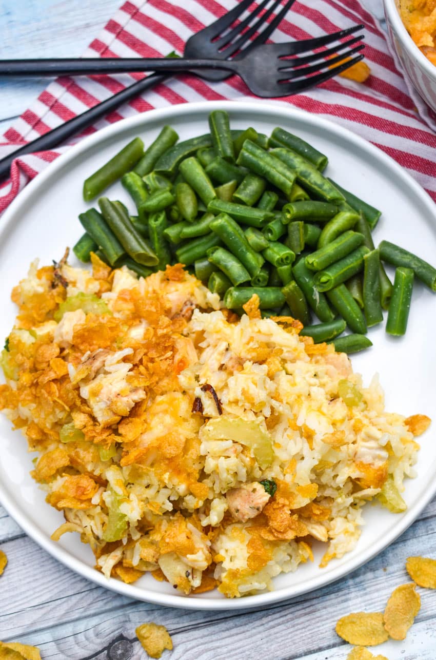 rotisserie chicken and rice casserole next to steamed green beans on a white plate