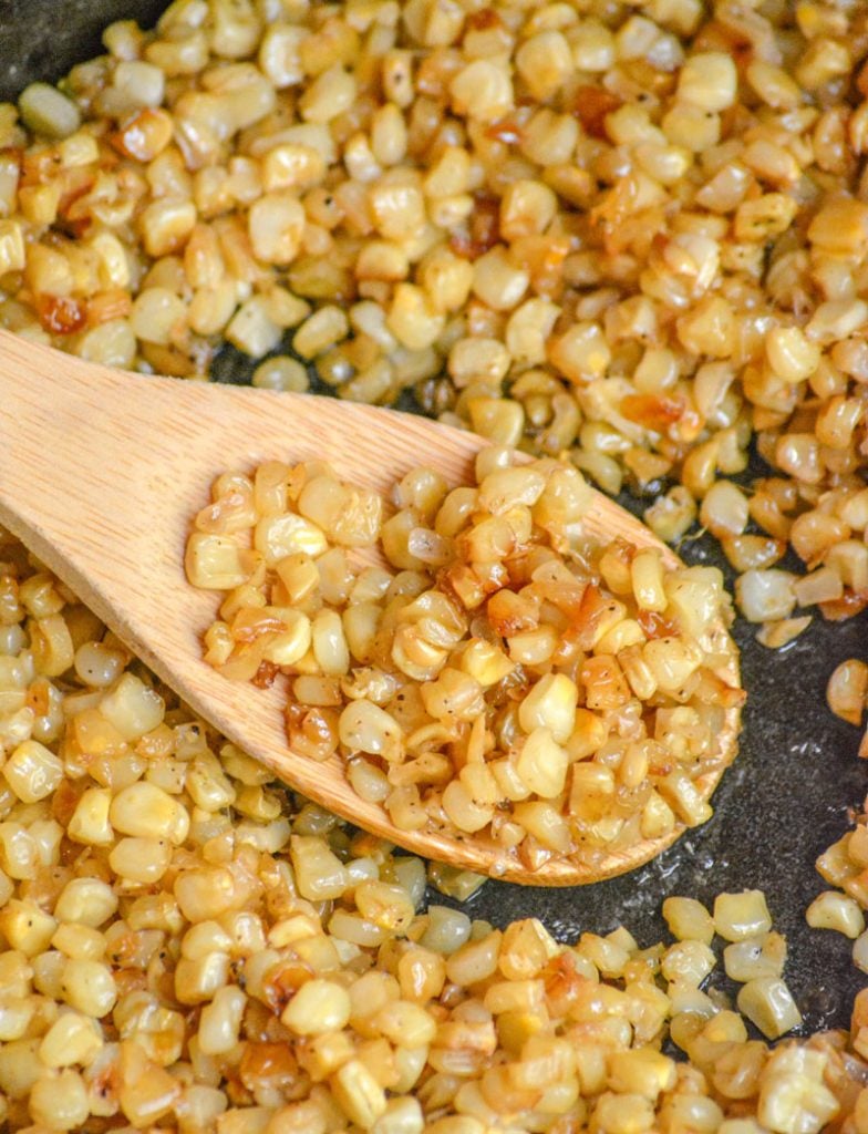 a wooden spoon show-casing Southern Fried Skillet Corn