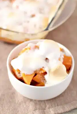 apple sauce sweet potato bake topped with melted marshmallows in a small white bowl