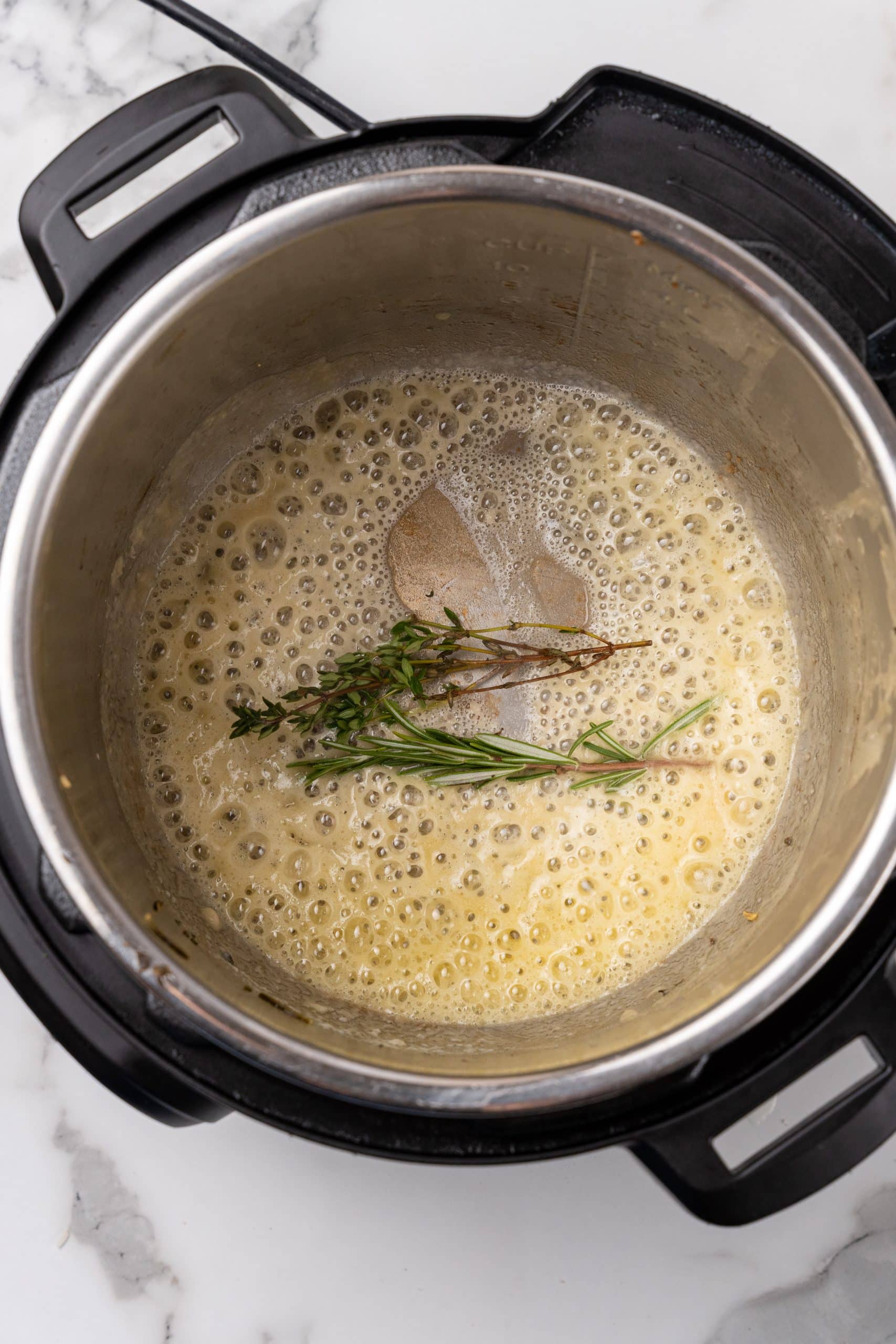 fresh herbs in sauteed butter in the bowl of an instant pot