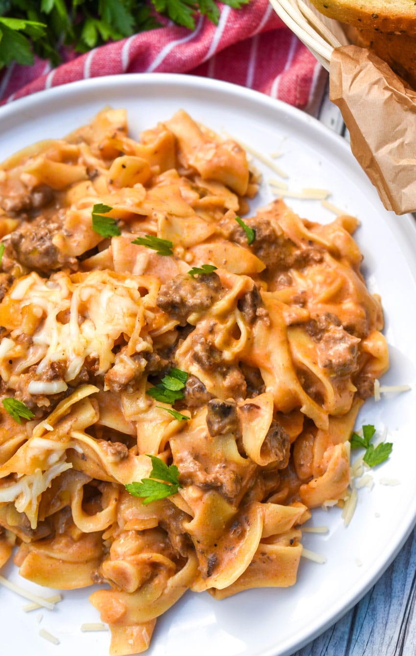 cheesy tomato beef noodle casserole on a white dinner plate