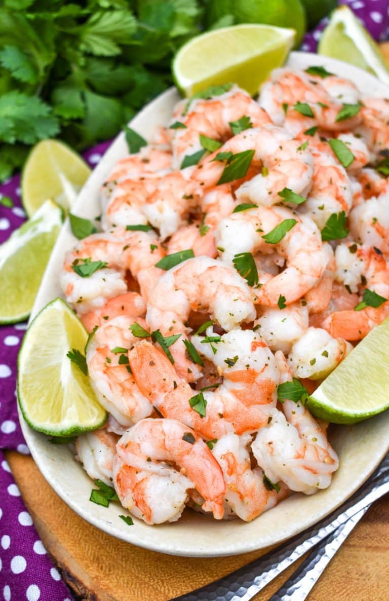 copy cat costco cilantro lime shrimp in a white dish with lime wedges on the side