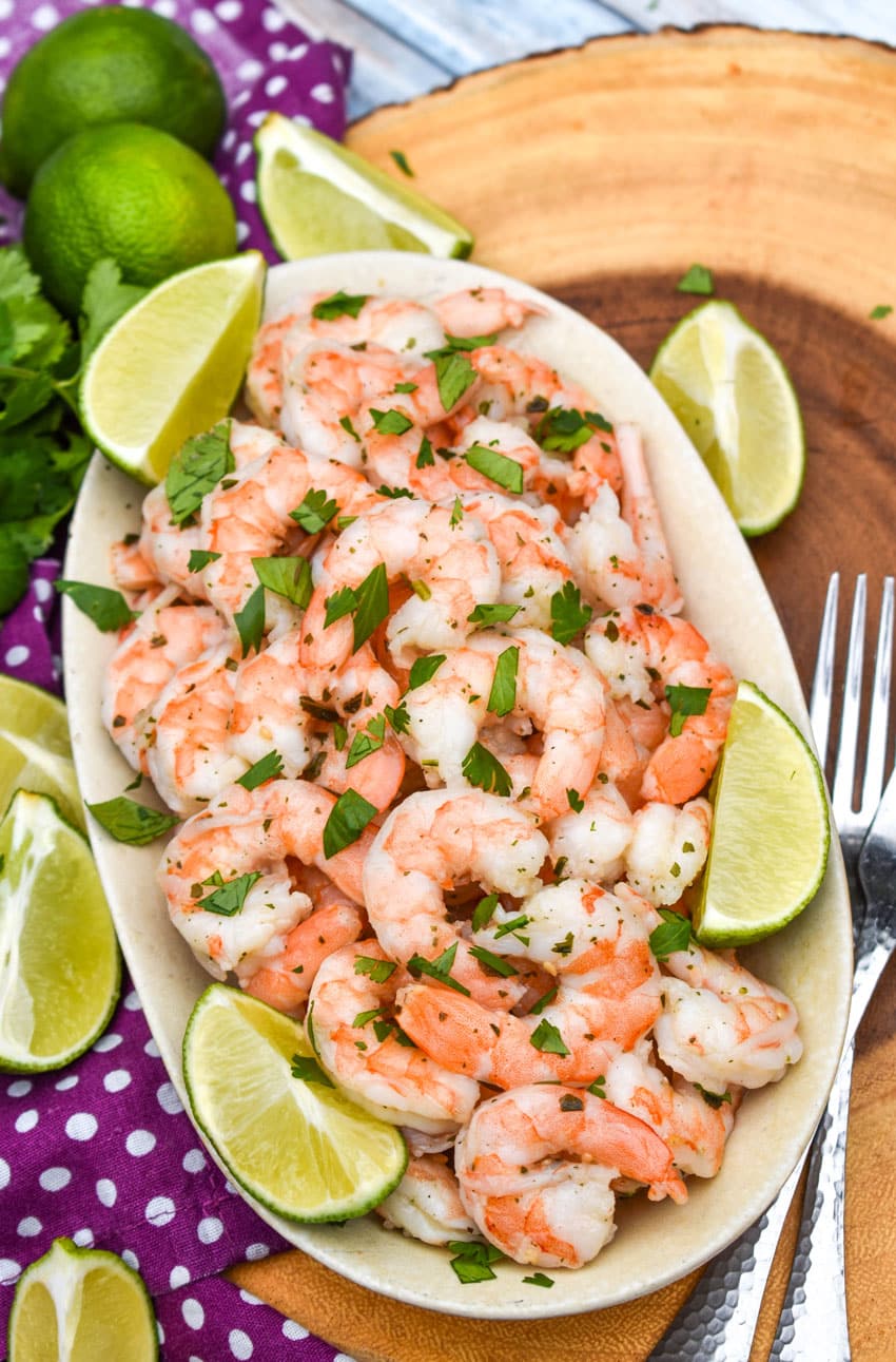 copy cat costco cilantro lime shrimp in a white dish with lime wedges on the side