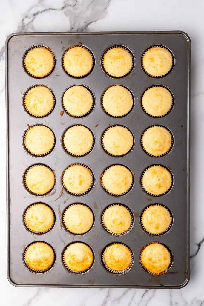 baked champagne cupcakes in a 24 count metal muffin tin