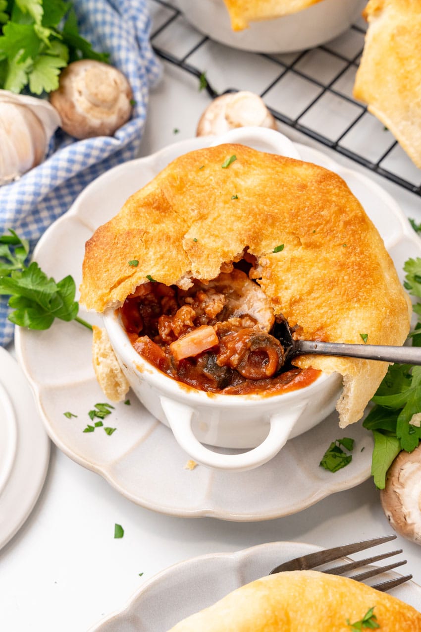 a silver fork scooping pizza pot pie out of a small white ramekin