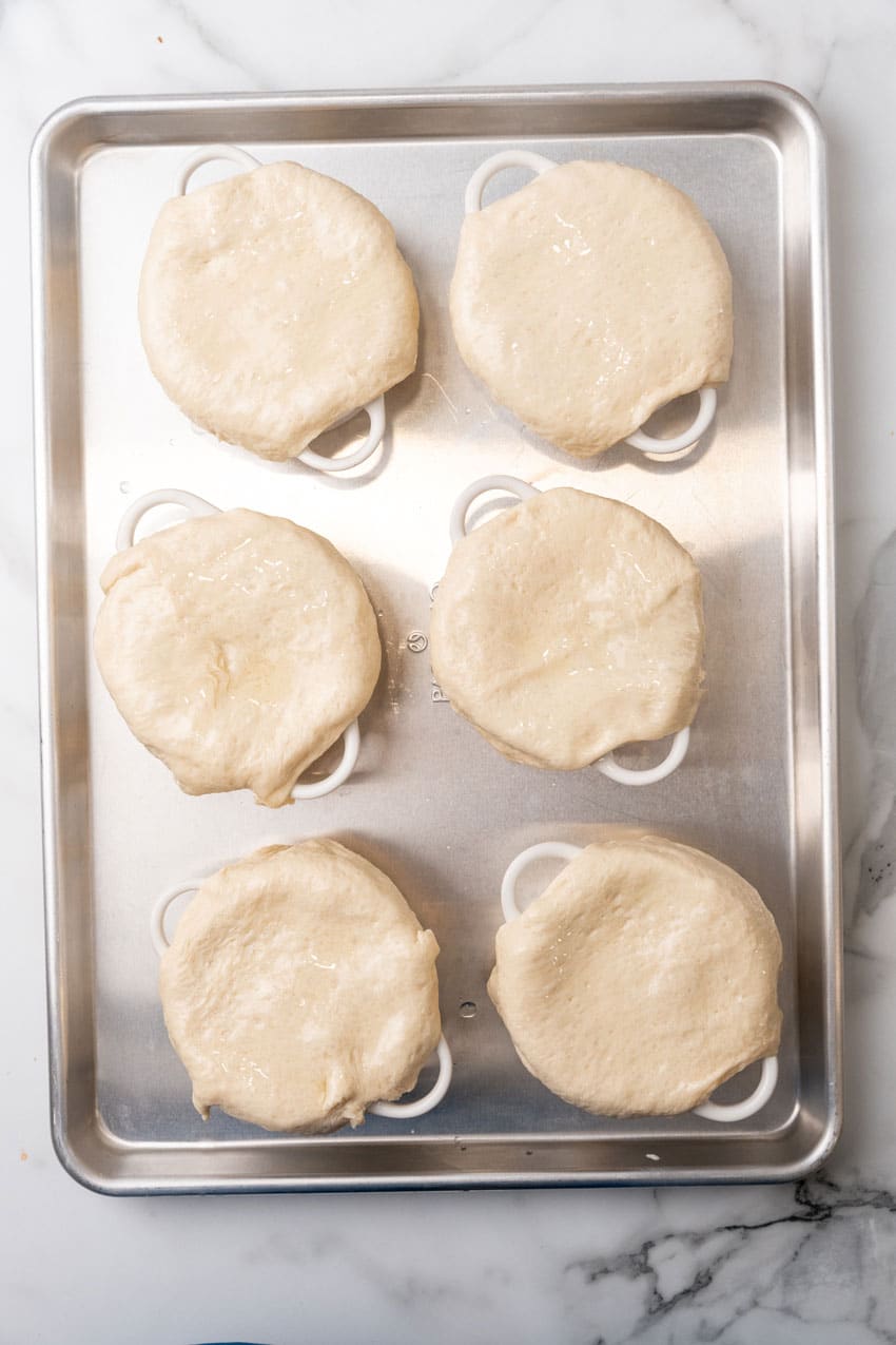 6 prepared pizza pot pies in ramekins arranged in two rows on a baking sheet